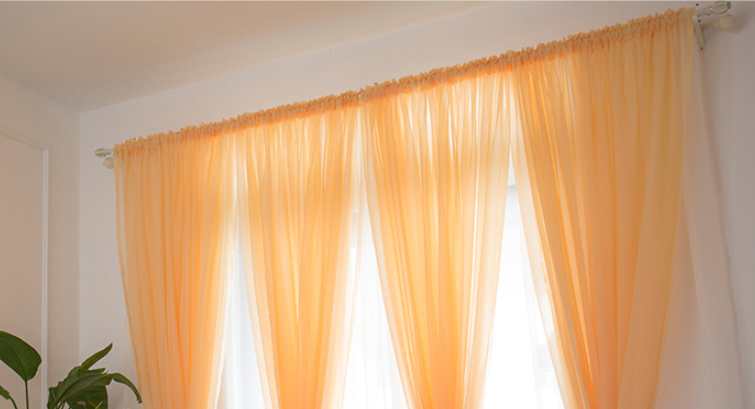 Orange rod pocket curtains in 6 times fullness